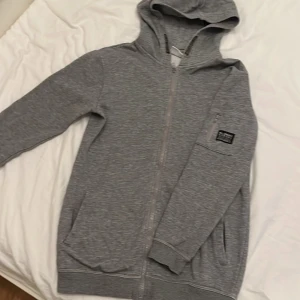 Grå hoodie från COPE - Säljer en grå hoodie från COPE i storlek 146/152. Den har en dragkedja framtill och en mysig huva. Perfekt för höst och vår! Det finns en liten fläck på framsidan som kan gå att tvätta bort, men annars i bra skick.