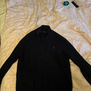 Marinblå Raffe half zip ! - Säljer en stilren svart tröja från Polo Ralph Lauren i storlek S som aldrig kommit till användning. Köptes för 2200kr på pondus och använts 2 gånger. Skriv för fler bilder 😄