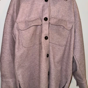 Ljuslila overshirt med knappar - Säljer en superfin ljuslila overshirt i mycket bra skick. Den har stora fickor fram och knäpps med svarta knappar. Perfekt för höst och vår när du vill ha något lätt men ändå stiligt. Passar både till vardags och lite mer uppklädda tillfällen. 🧥💜