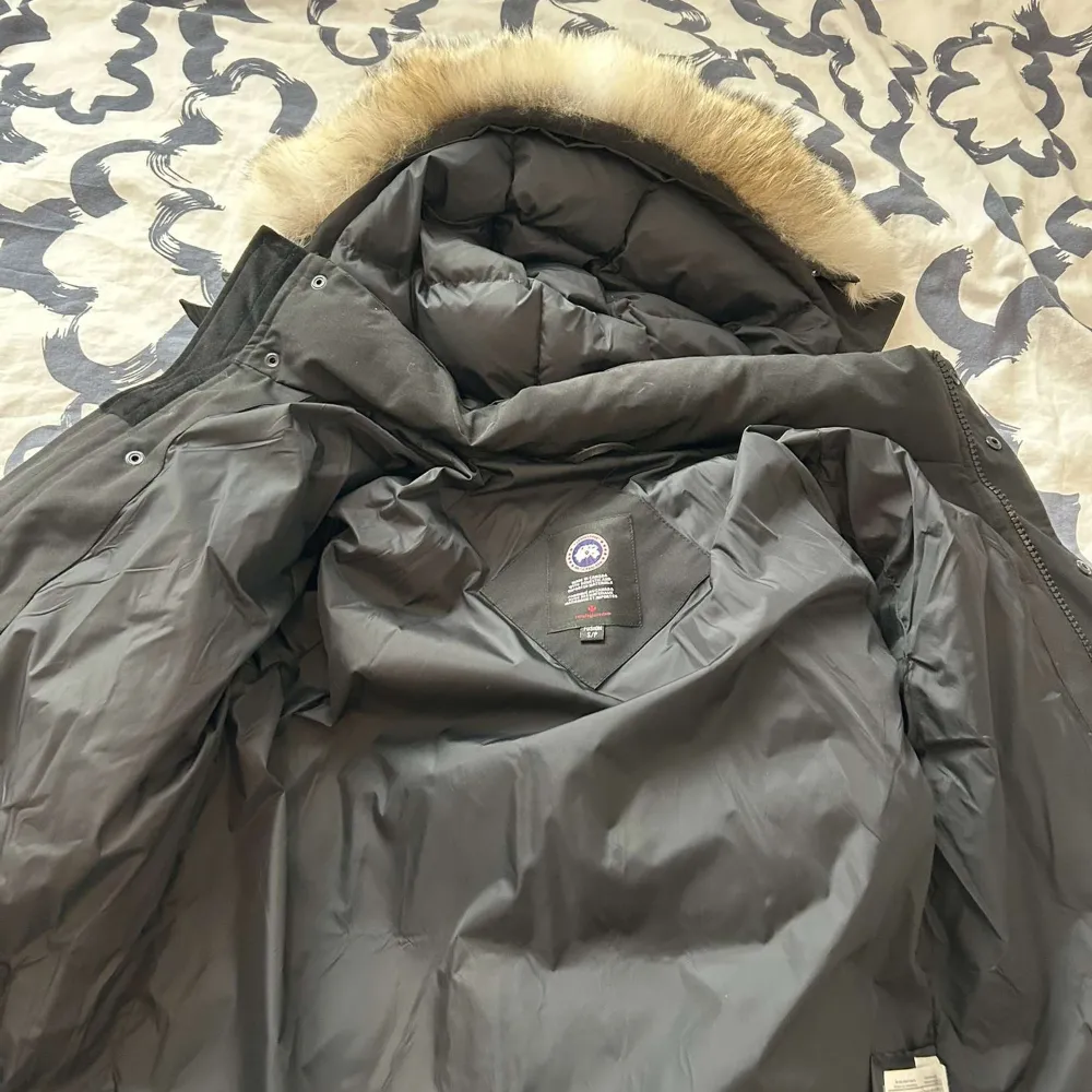 Säljer en svart dunjacka från Canada Goose i mycket bra skick. Jackan har en avtagbar huva med pälsdetalj och är perfekt för kalla vinterdagar. Den är långärmad och har en dragkedja framtill. Supervarm och stilren!. Jackor.