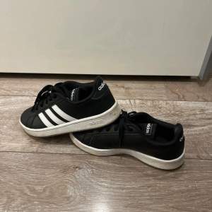 Säljer ett par klassiska svarta Adidas sneakers i storlek 36. De har de ikoniska vita ränderna på sidan och är i bra skick. 