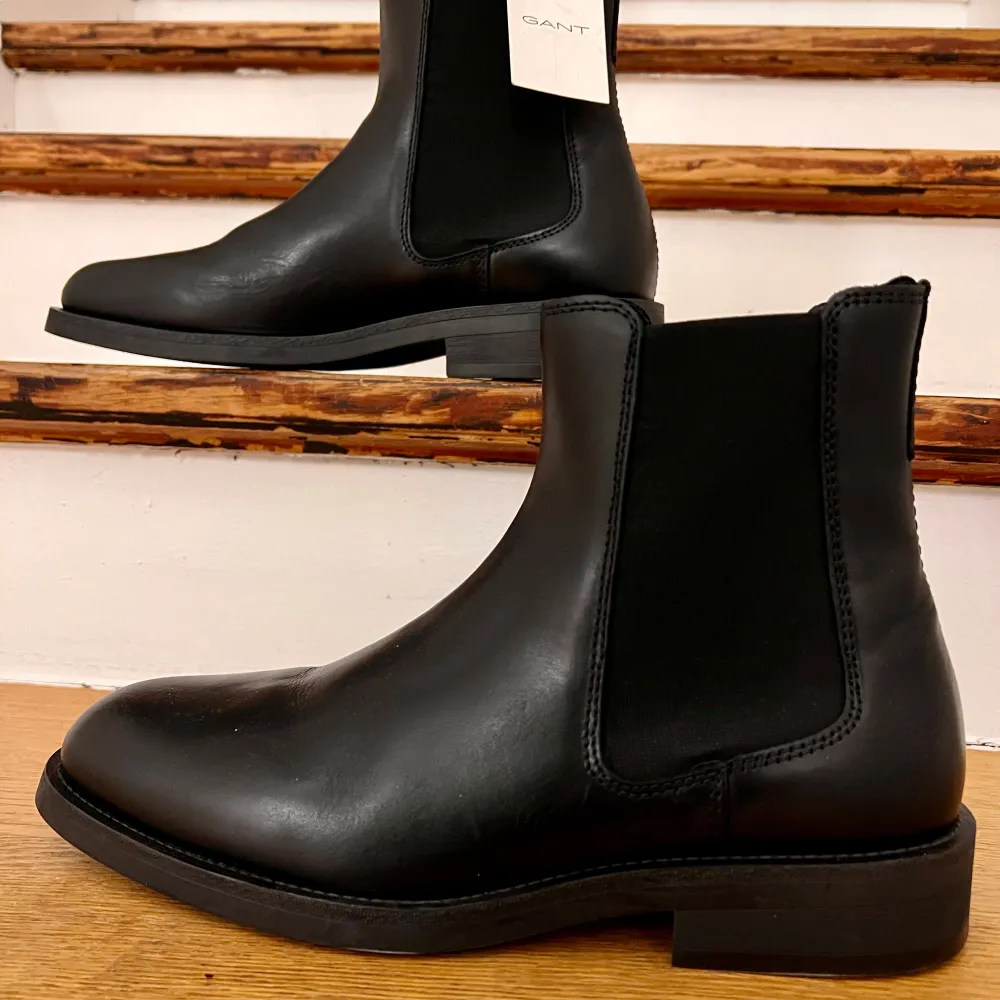 Snygga svarta Chelsea boots från Gant i skinn. Perfekta för höst och vinter med en stilren design och elastiska paneler på sidorna för enkel på- och avtagning. De har en robust sula som ger bra grepp. Passar både till vardags och festliga tillfällen.. Skor.