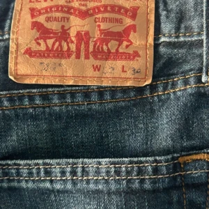 Levi's jeans i blå denim - Säljer ett par klassiska Levi's jeans i blå denim. De har en straight passform och är i mycket bra skick. Perfekta för både vardag och fest. Passar bra till alla säsonger och är ett måste i garderoben!