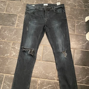 Jeans med slitningar - Säljer nu mina jeans i mörkblå som har coola slitningar vilket gör de väldigt unika. Bra skick exklusive hålen som är design:) skriv om frågor 