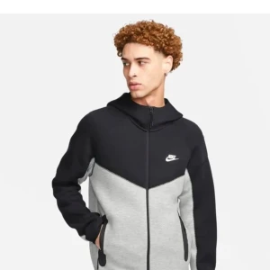 Svart och grå Nike teech - Säljer en snygg och bekväm svart och grå hoodie från Nike. Den har en dragkedja framtill och är perfekt för både träning och vardag. Hoodien har långa ärmar och en klassisk Nike-logga på bröstet. Perfekt för höst och vår! Den passar över s 