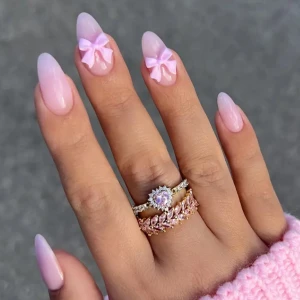 DIY Naturliga Lösnaglar - Snygga och naturliga lösnaglar för en snabb manikyr på 2 minuter. Setet innehåller 24 naglar i en mjuk beige nyans, med två naglar dekorerade med söta rosa rosetter. Perfekt för en elegant och bekväm look som du enkelt fixar själv hemma.