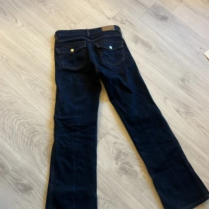 Jeans - Säljer dessa mörkblå low waist bootcut jeansen då dom har blivit för korta tyvärr. Är i längden short, och har orange/bruna stygn. Har använts fåtal gånger så är i väldigt bra skick. Köparen står för frakten💗
