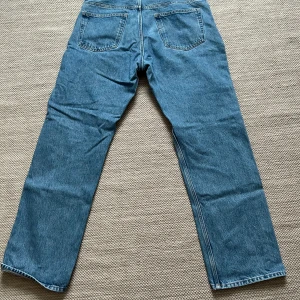 Blå jeans från Weekday - Säljer ett par klassiska blå jeans från Weekday i storlek W33 L32. De har en straight passform och är tillverkade i slitstarkt denim. Perfekta för både vardag och fest!