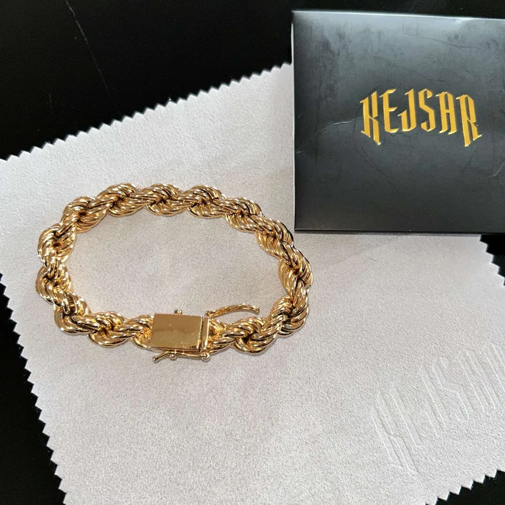 Elegant guldpläterat 18k armband från Kejsar med en tvinnad design och en dekorativ låsdetalj prydd med stenar. Perfekt för att ge en lyxig touch till din stil och till och med diamant på låset vilket ger unik touch och gör så hela armbanden skiner// armbanden köptes av de dyraste alternativ som fanns på kejsar hemsidan vilket är tjockleken 10 mm och med diamant lås, riktigt unikt. (Knappt använd) St ( 19,5cm ) . Asusteet.