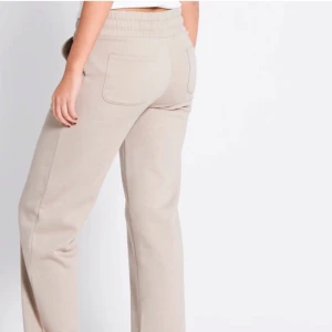 Beige/ bruna mjukisbyxor - Snygga och bekväma beige/ bruna mjukisbyxor med elastisk midja och snörning. Byxorna har en avslappnad passform och praktiska fikor! 