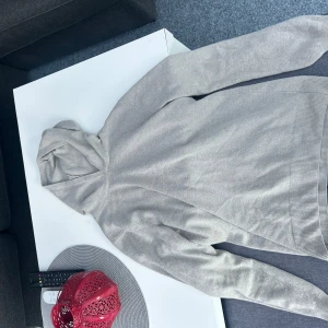 Beige kashmir pascalhoodie från Oscar Jacobson - Säljer en stilren beige kashmirhoodie från Oscar Jacobson i storlek XS. Tröjan är tillverkad i Italien och har en klassisk design med långa ärmar och en bekväm huva. Perfekt för en avslappnad look. Väldigt bra skick, skriv för mer info!