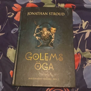 Golems öga - Säljer 'Golems öga', del 2 i Bartimaeus-trilogin av Jonathan Stroud. Boken är inbunden och har en mystisk omslagsdesign med en illustration av en golem. Perfekt för fantasyälskare som vill fördjupa sig i en magisk värld.