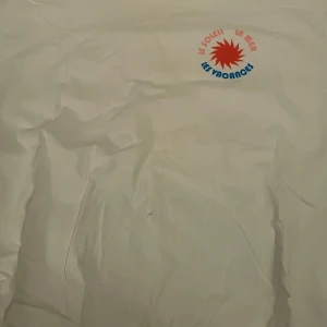 Vit t-shirt från BikBok med tryck - Säljer en vit t-shirt från BikBok med ett färgglatt tryck som säger 'Le Soleil La Mer Les Vacances' och 'St. Tropez 1980'. Perfekt för en avslappnad stil med en touch av retro. OBS. Har ett litet hål på framsidan som går att laga!