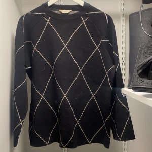 Svart tröja med rutmönster - Snygg svart tröja med ett elegant rutmönster i vitt. Tröjan har långa ärmar och en klassisk rund halsringning. Perfekt för en stilren look. Från objekt, storlek xs, nypris 699, går att pruta! 