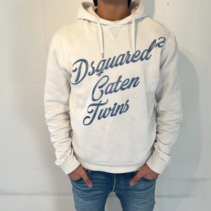 Dsquared2 hoodie - Tja! Säljer denna riktigt feta Dsquared2 hoodien i ett fint skick! På bilden är hoodien smått smutsig men tvättar den självklart innan köp! Det ”slitna och urtvättade” trycket i blått är dess design vilket gör denna hoodie ännu fetare! Väldigt bra hoodie som är enkel att matcha till outfits med 😁modellen på bilden är 170 cm och väger 62 kg och bär normalt en S-M vilket hoodien passar bättre på istället för en L som det står på necktagen🤝nypris~4000kr. äkta‼️skriv vid minsta intresse! Mvh DC 🔹
