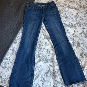 Blå bootcut jeans från Levi's - Säljer ett par blå bootcut jeans från Levi's. De har en snygg passform med normal midja. 