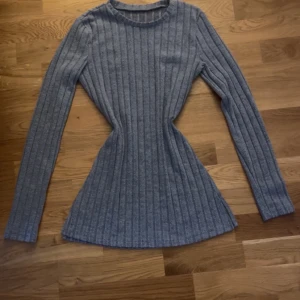 Ljus blå ribbad tröja från Shein - Säljer en stilren grå ribbad tröja från Shein. Tröjan har en klassisk rund hals och långa ärmar, perfekt för en avslappnad look. Den är tillverkad i ett mjukt och stretchigt material som ger en bekväm passform. Storlek S. 