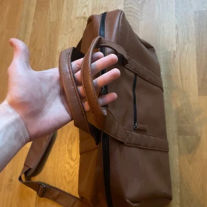 Läder Weekendbag/axelremsväska  - En mycket fin och välgjord weekendbag/axelremsväska från Ashford Ridge  Justerbar och vadderad axelrem  Slitstarka handtag  3 innefickor och 1 extern ficka med dragkedja   Mått: ca 50x30x30cm