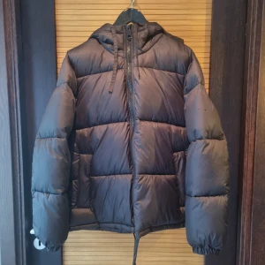 Svart pufferjacka med huva - Säljer en svart jacka med huva och dragkedja från H&M 