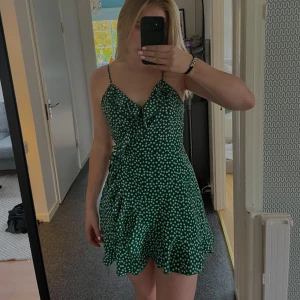 Klänning  - En blommig grön klänning med volang