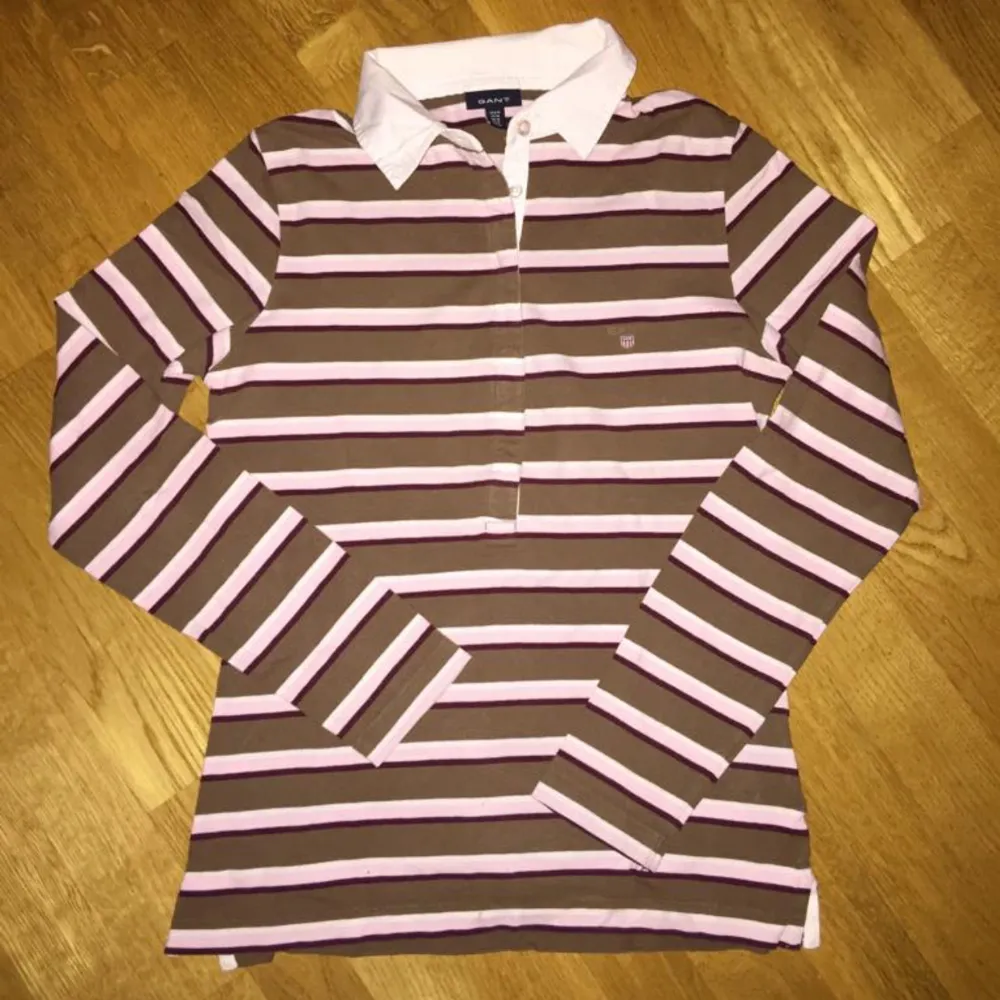 Säljer en randig pikétröja från Gant i brunt och rosa. Stl M. Bommulstrikå. Den har en klassisk vit krage och långa ärmar! Slits i sidorna. . Neuletakit & Villapaidat.