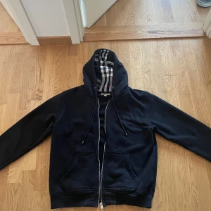 Burberry Hoodie - Säljer denna snygga burberry hoodie i fintfint skick utan skador eller deflekter, den sitter som M men lappen inuti visar på större vilket ej stämmer! Vid fler frågor eller funderingar samt fler bilder är de bara att skriva!