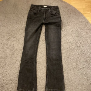 Svarta bootcut jeans - Säljer ett par snygga gråa bootcut jeans. De är lågmidjade med svart knapp. De är i bra skick och passar till det mesta.