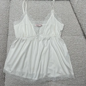 Linne - Vitt supergulligt linne från Nelly som tyvärr inte kommer till användning. Superskönt material & aldrig använt så i mycket bra skick (prislappen är dock borttagen. Storlek XXS🤍