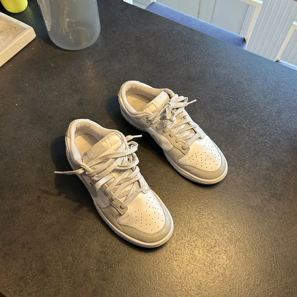 Säljer ett par gråa Nike Dunk sneakers i nyskick. De har en stilren design med snörning och är perfekta för både vardag och fest. Skorna är i storlek EU 42 och passar dig som gillar en klassisk och bekväm stil. Perfekta för vår och sommar!. Skor.