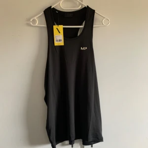 Svart träningslinne från MP - Säljer ett svart träningslinne från MP i storlek XS. Perfekt för gymmet eller löprundan. Linnet är helt nytt aldrig använt. Orginalförpakning följer med. 