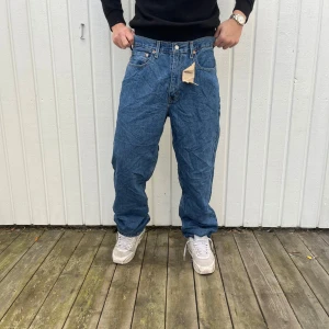 Levis 550 blå jeans - Säljer ett par klassiska Levis 550 jeans i blå denim. De har en relaxed fit och är perfekta för en casual look. Jeansen är i nyskick och har den ikoniska Levis-lappen bak. Perfekta för både vardag och fest!