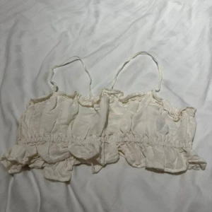 Vit knytbar topp - Vit liten topp som man knyter i ryggen. Aldrig använd endast   testad då jag inte tycker den passar mig. Skriv vid intresse! Nypris 199kr har jag för mig