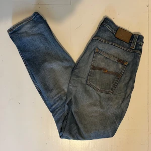 Blåa Nudie jeans - Tjena, jag sälje mina feta Nuide jeans i storlek W32 L34. Dom är billiga för att dom har hål vid skrevet som jag har försökt laga men det blev sådär, det är också hål i fram fickorna. Byxorna är i modellen grim trim också. Skriv till mig vid frågor! 