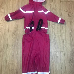 Rosa regnkläder i stl 86/92 - Regnkläder passar perfekt till hösten och vintern. Den enda defekten som finns är på ett av benen där ”tyget” gått upp lite. Färg av leran ska gå att tvätta bort!