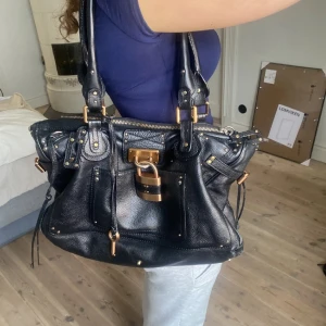  Svart Chloé Paddington väska - Väskan är stor och rymlig och passar perfekt att ha till skolan eller vad som helst, väskan är i bra skick förutom en reva i mittenfacket men det utgör inget problem och märks inte av. Skulle vara lätt att sy ihop och går att använda som gömställe!🩷