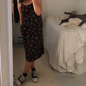 svart långklänning - säljer denna svarta långklänning med körsbär på från Shein! Aldrig använd men såå fin!❤️