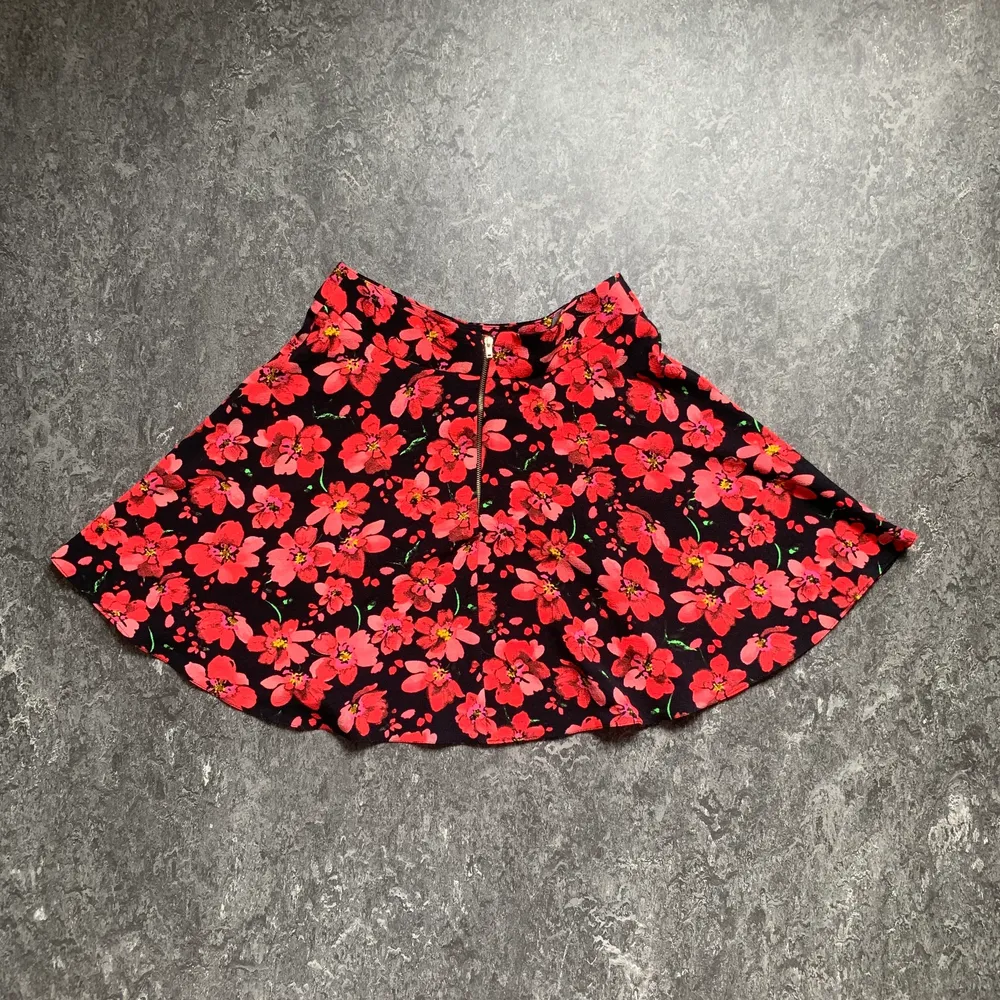 En söt rödblommig kort kjol som är perfekt till sommaren i storlek 34. Använd men i bra skick. Frakt tillkommer.. Kjolar.