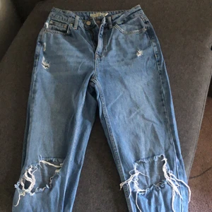 Mom jeans med hål - Blåa ”mom jeans” med hål i knäna och bak. 