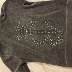 Grå juicy couture kofta - Grå juicy couture kofta i stl s. Den har ett litet hål som knappt syns vid fickan (se sista bild)