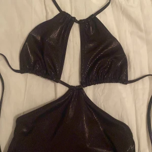 Svart klänning  - En svart tight klänning från HM med avskurningar och knyten i rygg och nacke! Ny pris 200kr, aldrig använd!