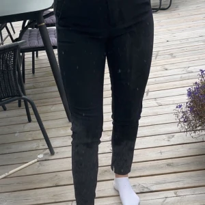 Svarta kostymbyxor strl 36 - Svarta ankellängds kostymbyxor med liten slits längst ner för Nelly. 