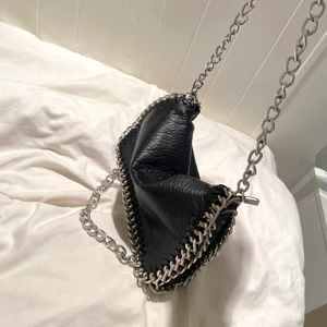 Tiamo väska - Säljer nu min svarta tiamo väska. Väskan är i väldigt fint skick. Inget rost någonstans och lädret ser helt orört ut. Jag har själv satt ditt extra kedjan längst ner vid väskan och om man vill ta bort den finns detmöjlighet att få av den innan avlämning.💗