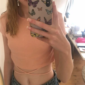 T-shirt med snören - En jättefin rosa t-shirt som man knyter runt kroppen! Använd ca 2-3 gånger och är i jättefint skick💗