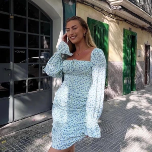 Capri dress Adoore - En underbar klänning från adoore som är fantastiskt smickrande på kroppen och otroligt fina armar. Capri dress blue flowers. Justerbar i längden. Använd Max en gång så i princip nyskick!  Nypris 1395kr strl. 44 (är mindre i storlek, tajtare runt midjan) 