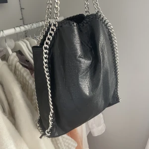 Priscilla Väska L svart  - Fin väska i perfekt storlek som tyvärr inte kommer till användning längre. Bandet vid kedjan längst mer på väskan är av (har knutit en tillfällig knut, sista bilden). Men inget man lägger märke till 💕Nypris 599kr.