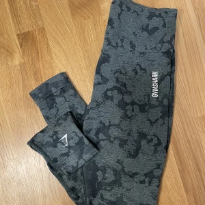 Gymshark obsedian green strl S - Gymshark adapt camo i färgen obsedian green storlek S. Slutsålda på hemsidan sedan länge, stretchiga och högmidjade. Fint skick🌸