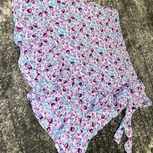 Omlottkjol  - En fin omnlottkjol i blommigt tyg, endast använd på skolavslutningen 1 gång. Den är som ny. Finns dragkedja i sidan. 80kr + 52kr frakt