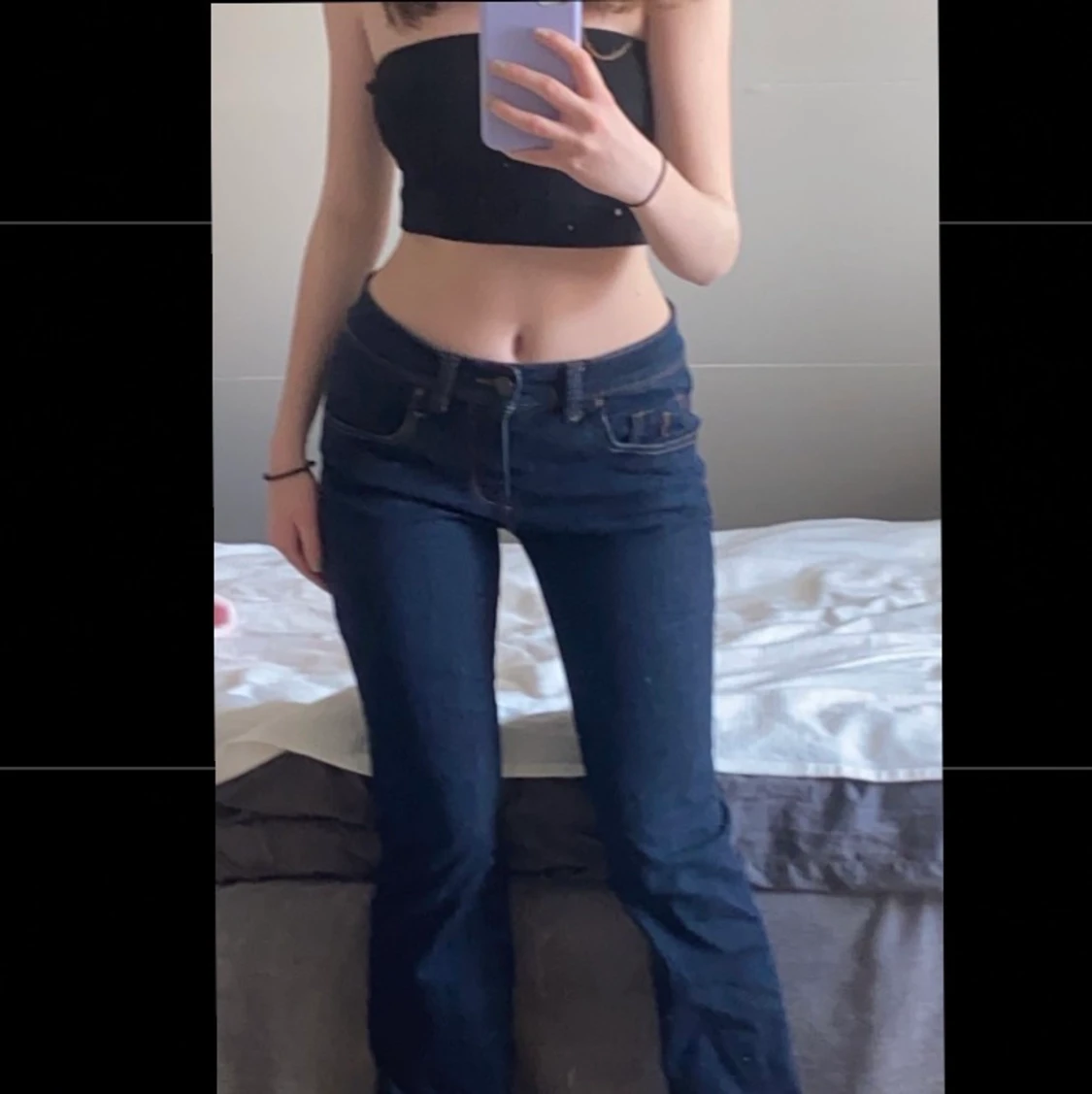 Ett par lågmidjade jeans i mörkblå färg