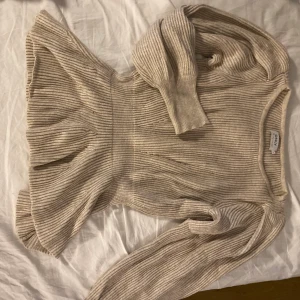 Stickad tröja  - Jättefin stickad tröja med fina detaljer i axlarna. Även insydd i midjan för mer form på kroppen. OBS fick välja färgen brun för beige fanns ej