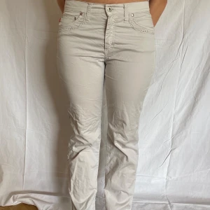 Low waist beige byxor - Snygga low waist byxor som är beiga men mot det ljusare hållet. Fina detaljer med brodyr och diamanter på backfickorna och på framfickorna. 